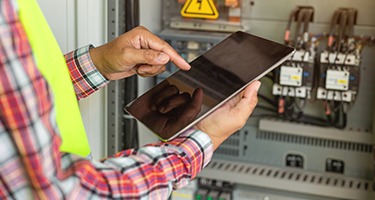 Man inputting digital work order into a tablet from a work site.
