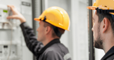 Two people in hard hats looking off camera.